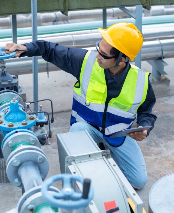 Engineer checks water tank valves, equipment related to hot water production pipelines. Engineer checks water tank valves, equipment related to hot water production pipelines.