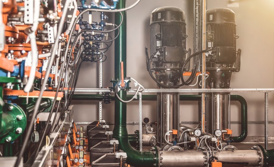 Urban modern powerful pipelines. Industrial pumps in an engine room. Industry interior of water pump