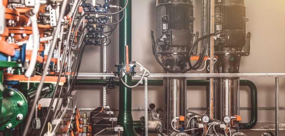Urban modern powerful pipelines. Industrial pumps in an engine room. Industry interior of water pump